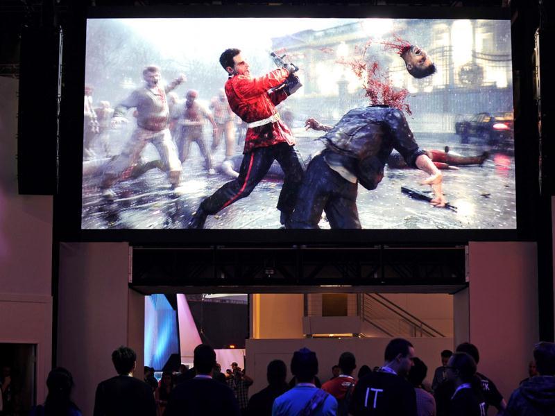 Attendees walk under large screen showing a scene from the new video game 'Zombie U' develpoed by Ubisoft at the E3 gaming conference in Los Angeles, California. Kevork Djansezian/Getty Images/AFP Attendees walk under large screen showing a scene from the new video game 'Zombie U' develpoed by Ubisoft at the E3 gaming conference in Los Angeles, California. Kevork Djansezian/Getty Images/AFP