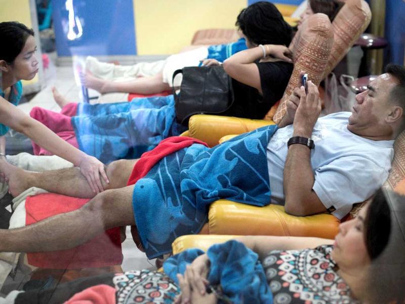 A man gets a foot massage while using his smartphone at a shopping mall in Bangkok. A recent Facebook-sponsored study shows smartphone owners are often connected all day. People can be found glued to their smartphones even while crossing the street, creating a disconnect with their immediate surroundings. AFP Photo A man gets a foot massage while using his smartphone at a shopping mall in Bangkok. A recent Facebook-sponsored study shows smartphone owners are often connected all day. People can be found glued to their smartphones even while crossing the street, creating a disconnect with their immediate surroundings. AFP Photo
