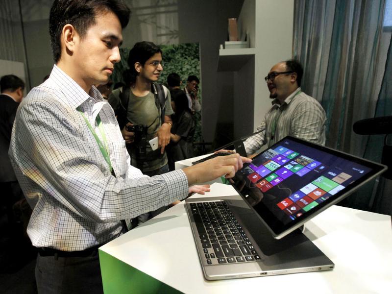 An Acer employee displays a new tablet-laptop hybrid Aspire R7 at an international press conference on the eve of the opening of Computex, one of the world's largest IT exhibitions, in Taipei. Photo: AP/Wally Santana An Acer employee displays a new tablet-laptop hybrid Aspire R7 at an international press conference on the eve of the opening of Computex, one of the world's largest IT exhibitions, in Taipei. Photo: AP/Wally Santana