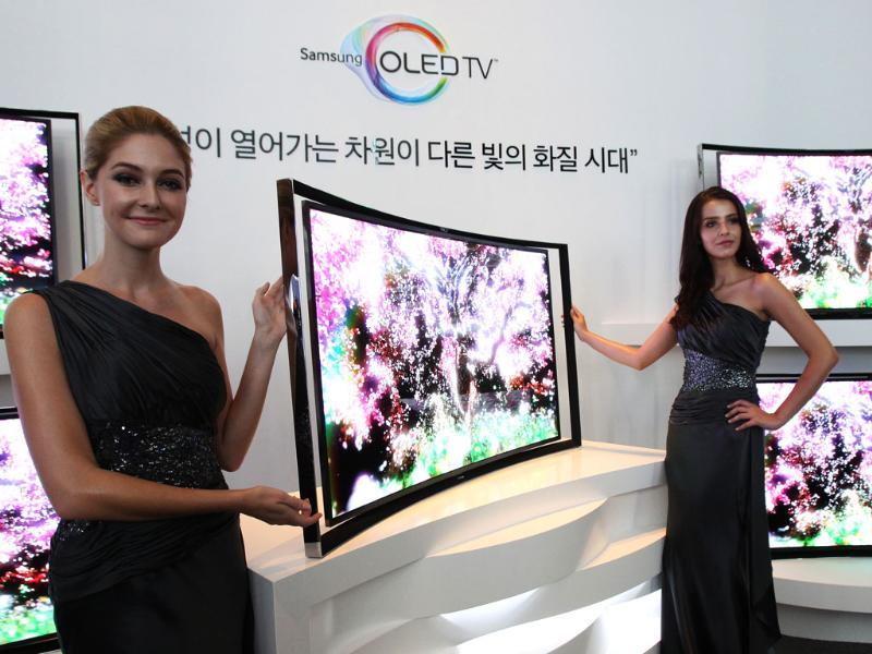 Models pose with a Samsung Electronics Co.'s 55-inch curved OLED TV during a press conference at its headquarters in Seoul. Photo: AP/Ahn Young-joon Models pose with a Samsung Electronics Co.'s 55-inch curved OLED TV during a press conference at its headquarters in Seoul. Photo: AP/Ahn Young-joon