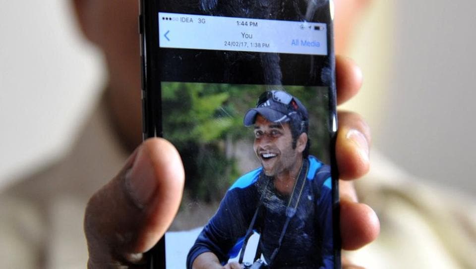 Jagan Mohan Reddy holds a smartphone with an image of his son Alok Madasani at his residence in Hyderabad on February 24, 2017, after Alok was injured in a shooting in the US state of Kansas.