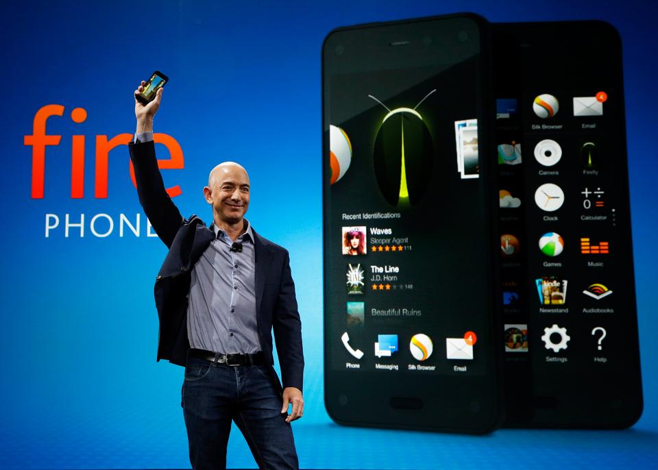 Amazon CEO Jeff Bezos holds up the new Amazon Fire Phone at a launch even.