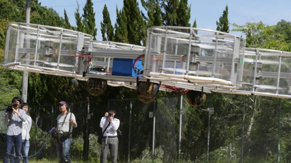 Journalists film Cartivator’s flying car during its demonstration in Toyota, Japan.