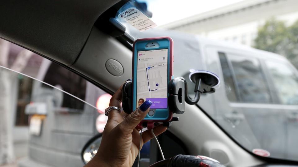 Maya Jackson, a Lyft driver from Sacramento, responds to a ride request on her smartphone during a photo opportunity in San Francisco, California.