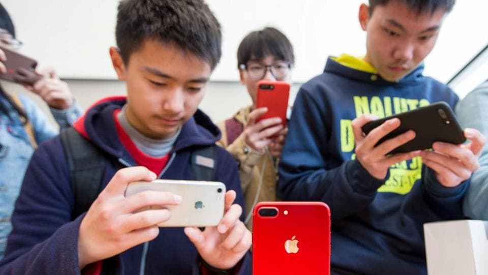 Customers take pictures of a red iPhone in an Apple store in Nanjing, Jiangsu province of China. The data-theft suspects, who worked in direct marketing and outsourcing for Apple in China, allegedly charged between 10 yuan ($1.50) and 180 yuan ($26.50) for pieces of the illegally extracted data.