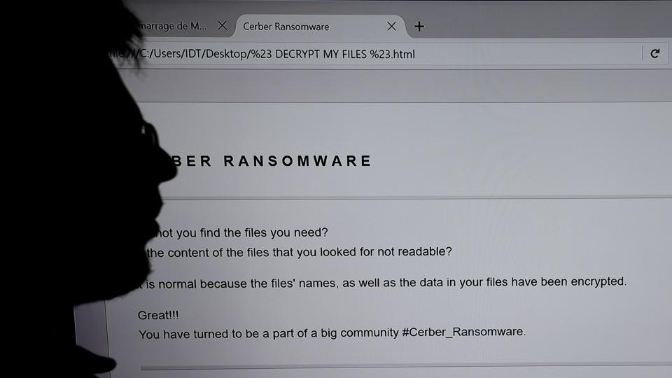 This file photograph shows an IT researcher as he stands next to a giant screen of a computer infected by a ransomware at the LHS (High Security Laboratory) of the INRIA (National Institute for Research in Computer Science and Automation) in Rennes. Several multinational companies said June 27, 2017, that they had been targeted in an international cyberattack which started in Russia and Ukraine before spreading to western Europe.