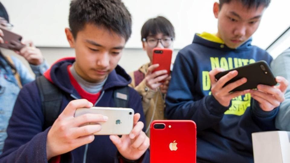 Customers take pictures of a red iPhone in an Apple store in Nanjing, Jiangsu province, China on March 25.