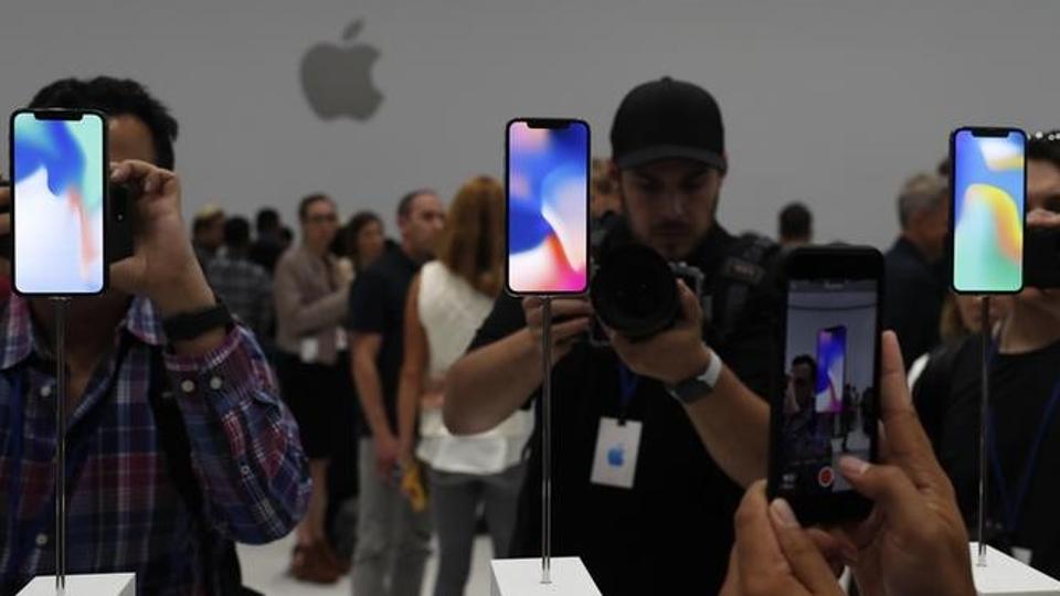 Attendees take pictures of new iPhone models during an Apple launch event in Cupertino, California, on Tuesday.