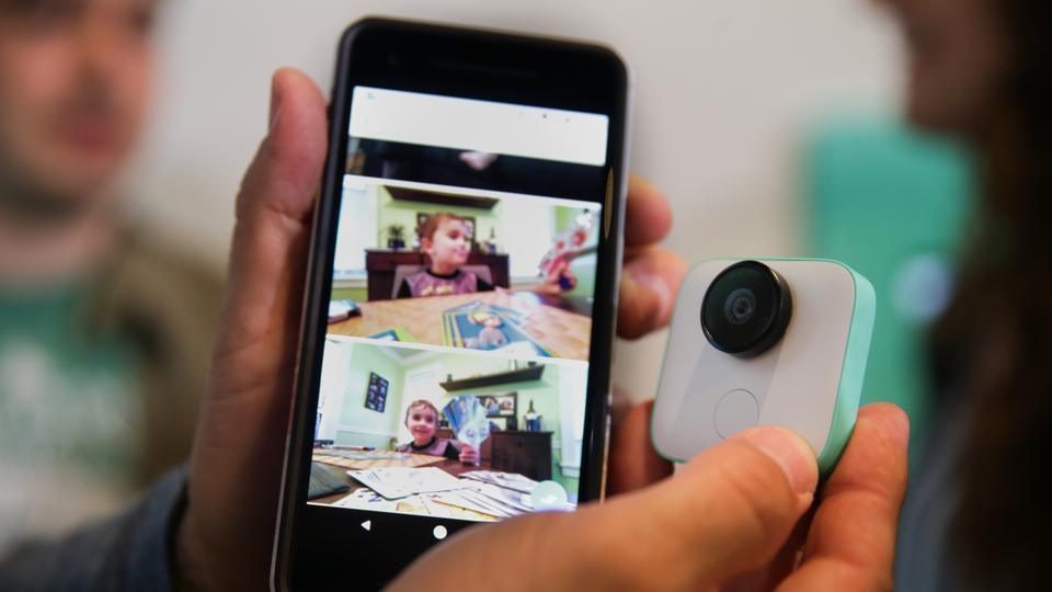 A Google employee holds up the new Pixel 2 smartphone and Google Clips wireless camera at a product launch event on October 4, 2017 at the SFJAZZ Center in San Francisco, California.