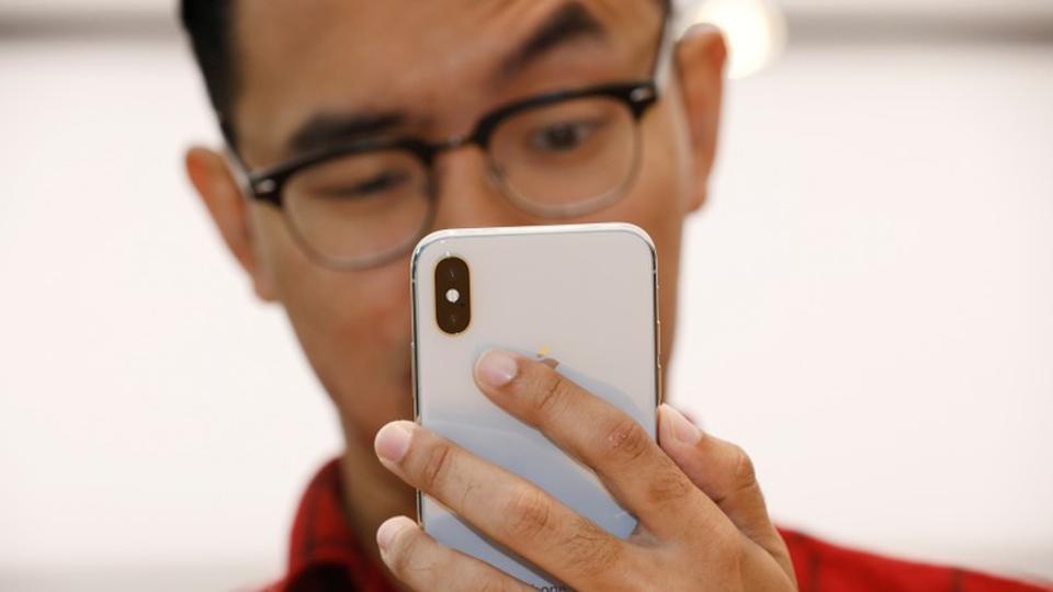 A man tries out the Animoji feature on an iPhone X during its launch at the Apple store in Singapore.
