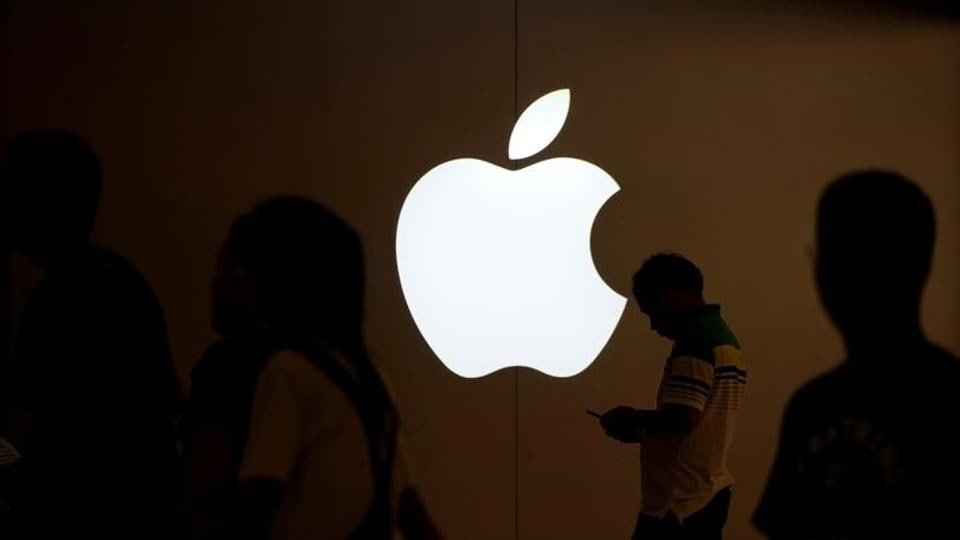 A man looks at the screen of his mobile phone in front of an Apple logo outside its store in Shanghai, China July 30, 2017.