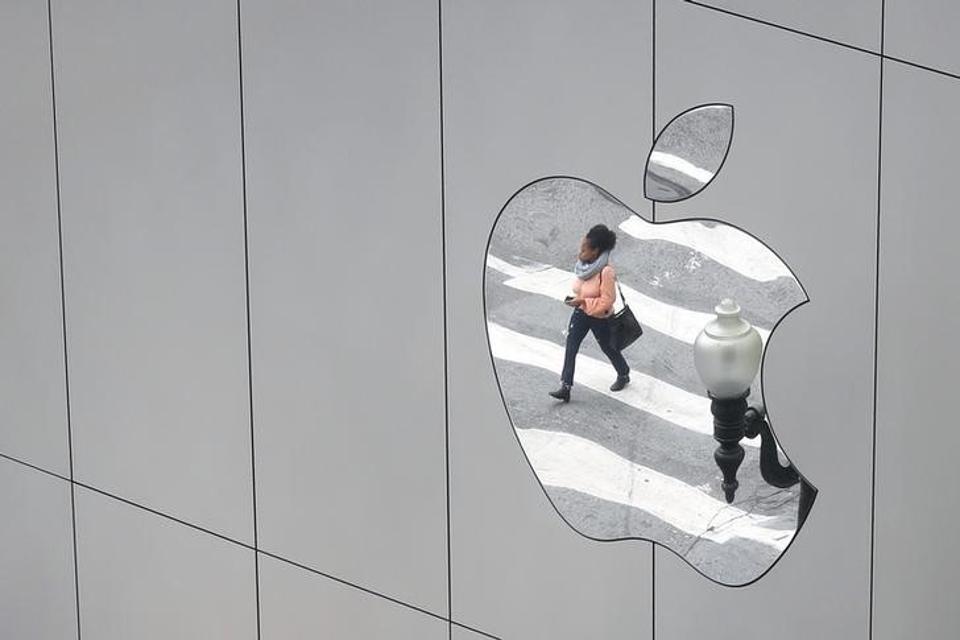 A woman is reflected in a Apple store logo in San Francisco, California, U.S., August 21, 2017. REUTERS/Kevin Coombs/Files