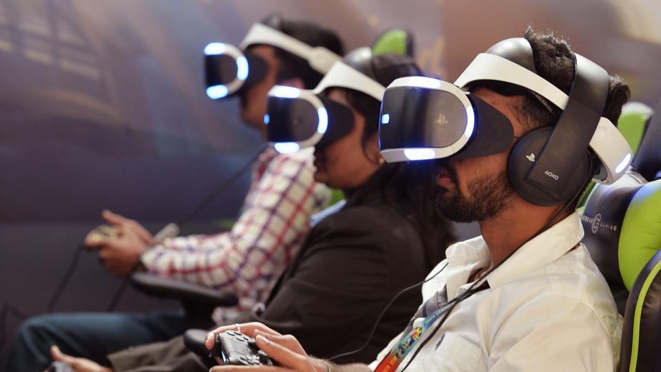 Gamers wearing virtual reality (VR) glasses play games at a stall during the India Gaming Show South 2018 expo at the Bangalore International Exhibition Centre on January 19, 2018.