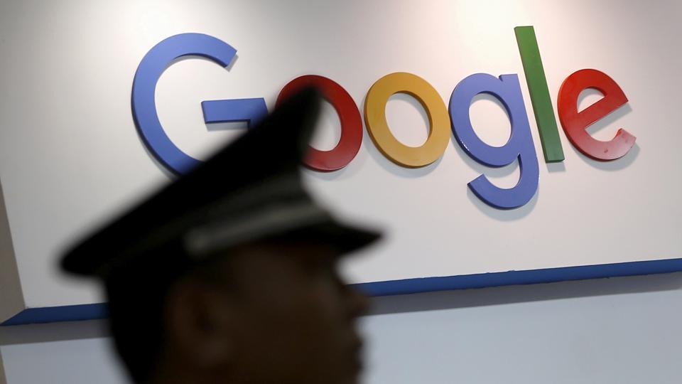 A security guard keeps watch as he walks past a logo of Google in Shanghai, China, April 21, 2016.