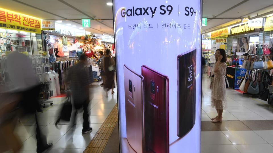 Pedestrians walk past an advertisement for the Samsung Galaxy S9 and S9+ at an underground shopping area in Seoul on July 31, 2018. Pedestrians walk past an advertisement for the Samsung Galaxy S9 and S9+ at an underground shopping area in Seoul on July 31, 2018.