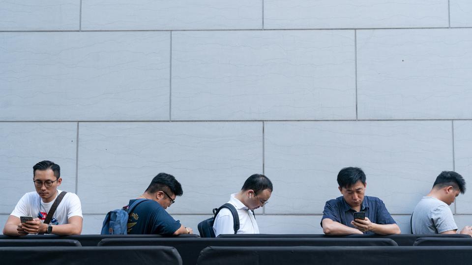 Customers stand in line outside an Apple Inc. store during the launch of the iPhone XS and Apple Watch Series 4 device in Hong Kong, China, on Friday.