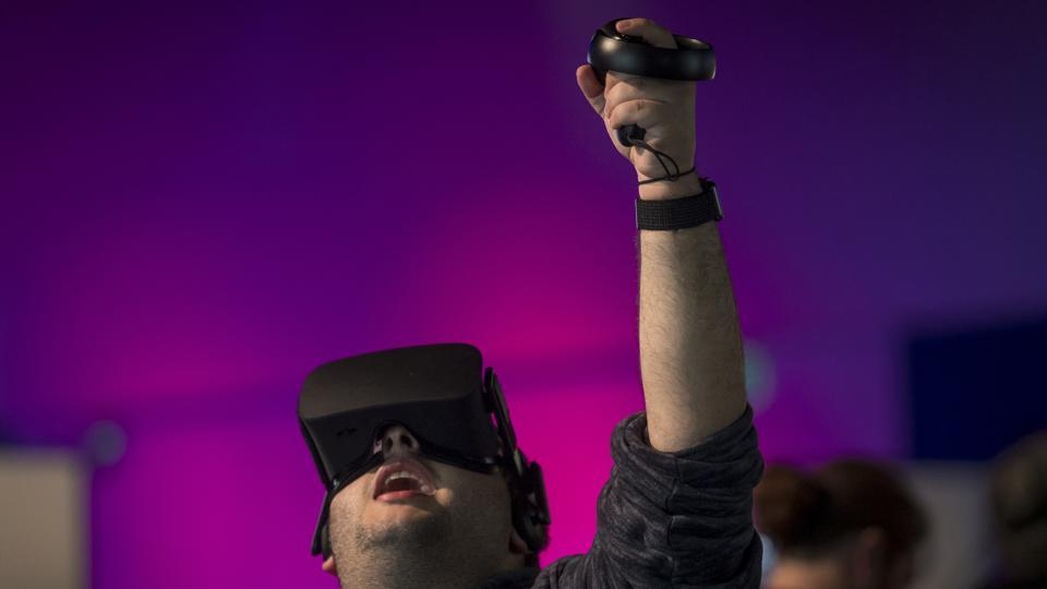 An attendee uses the Oculus VR Inc. Rift virtual reality (VR) headset and controllers during the Oculus Connect 5 product launch event in San Jose, California, U.S., on Wednesday, Sept. 26, 2018.