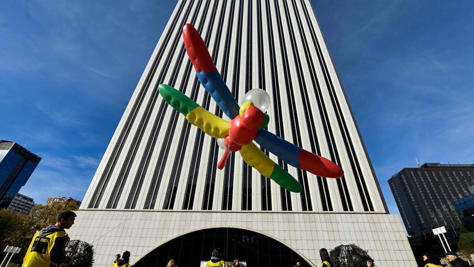Amnesty International activists hold a giant dragonfly-shaped balloon with a banner reading 