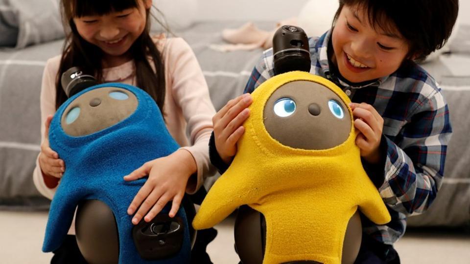 (Representative image) Children hold GROOVE X's new home robot LOVOT at its demonstration during the launch event in Tokyo