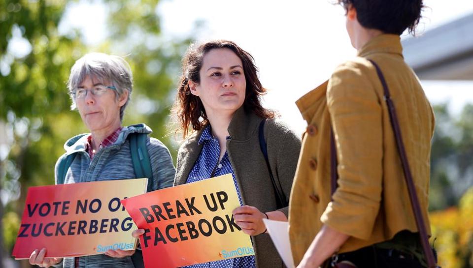 Arielle Cohen, a 30-year-old activist from Pittsburgh, PA., center, holds a sign during a protest outside the Facebook 2019 Annual Shareholder Meeting in Menlo Park.