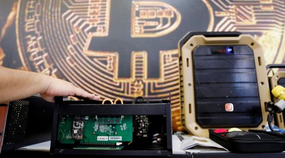 FILE PHOTO: A cryptocurrency mining computer is seen in front of bitcoin logo during the annual Computex computer exhibition in Taipei, Taiwan