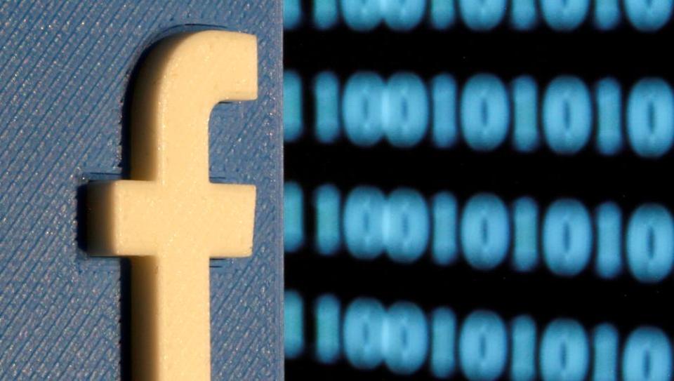 A 3-D printed Facebook logo is seen in front of displayed binary code in this illustration picture, June 18, 2019.