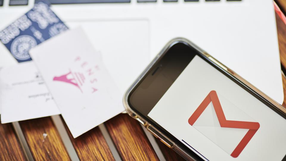 The Google Inc. Gmail logo is displayed on an Apple iPhone.