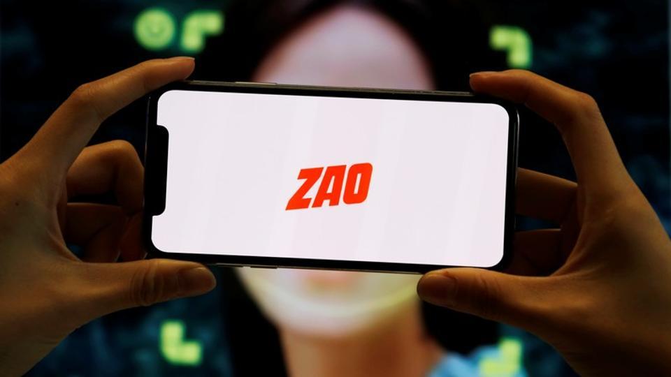 The logo of the Chinese app ZAO, which allows users to swap their faces with celebrities and anyone else, is seen on a mobile phone screen in front of an advertisement of the app, in this illustration picture taken September 2, 2019.