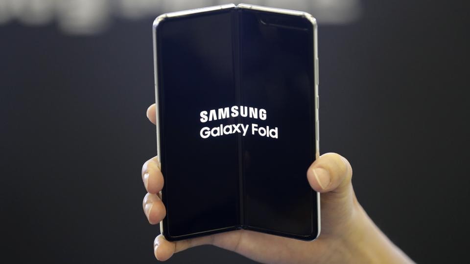 An employee holds the Samsung Electronics Co.'s Galaxy Fold for a photograph at a shopping mall in Seoul, South Korea, Friday, Sept. 6, 2019. Samsung's newest Galaxy Fold went on sale in South Korea on Friday.
