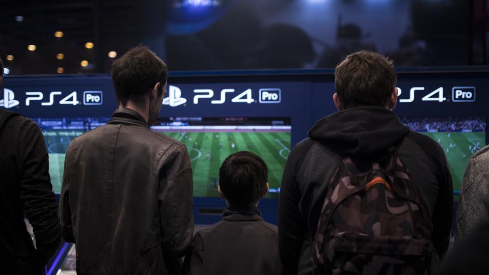 In this Nov. 3, 2017, photo, visitors play FIFA 18 video game on Playstation 4 Pro (PS4) at the Paris Games Week in Paris.