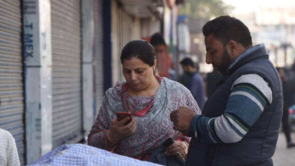 Srinagar, India – October 14, 2019: People seen using mobile phones at a marketplace in Srinagar, Jammu and Kashmir, India, on Monday, October 14, 2019.