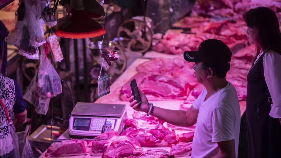 A customer uses his smartphone to scan a quick response (QR) code for payment at a pork stall inside the Dancun Market in Nanning, Guangxi. Image used for representational purpose only.