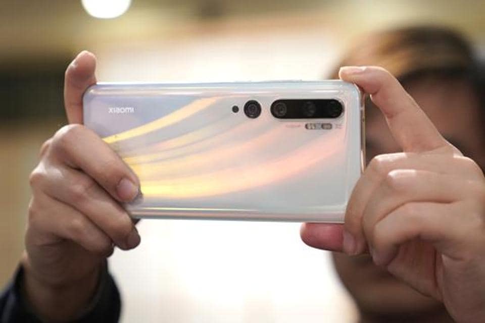 A Xiaomi Corp. employee demonstrates the company's Mi Note 10 smartphone.