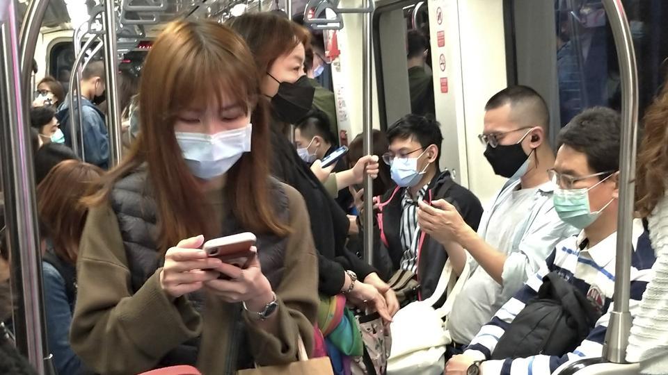People wear face masks to protect against the spread of the coronavirus on MRT in Taipei, Taiwan, Saturday, March 7, 2020.