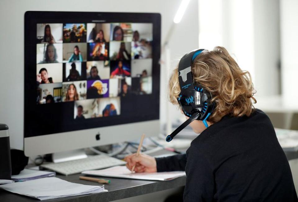 A student takes online classes at home, with his companions, using the Zoom APP during the coronavirus disease (COVID-19) outbreak in El Masnou, north of Barcelona, Spain April 2, 2020. REUTERS/Albert Gea