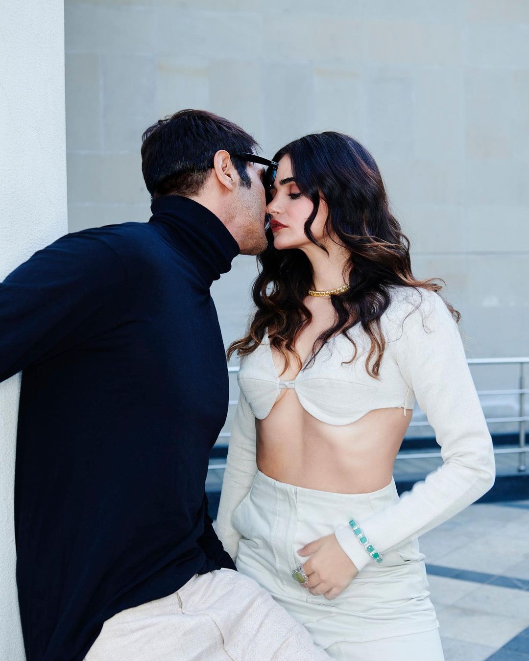 या फोटोशूटने अर्जुन आणि गॅब्रिएला यांनी पुन्हा एकदा नेटकऱ्यांचं लक्ष वेधून घेतलं आहे. या फोटोशूटमध्ये गॅब्रिएलाने फुल स्लीव्हज आणि किलर व्हेस्ट लाइन असलेला पांढरा ब्रॅलेट टॉप घातला आहे. त्यासोबत सोन्याचा नेकलेस, बोटांमध्ये अंगठी, पन्ना जडवलेले ब्रेसलेट आणि काळा सनग्लासेस घातला आहे. सोबतच अर्जुननेही काळा सनग्लासेस घातला आहे.