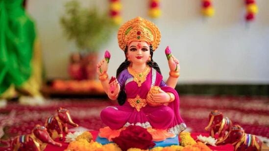 దీని తరువాత ఒక చెక్క పీఠపై శుభ్రమైన ఎరుపు రంగు వస్త్రాన్ని వేయాలి. లక్ష్మీ దేవి, వినాయకుడి విగ్రహాలు లేదా చిత్రాలను ఉంచండి. ఫోటో ముందు నేలపై కొంత బియ్యాన్ని ఉంచి, దానిపై ఒక కుండలో నీటిని నింపండి.