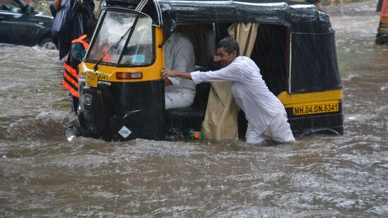 థానేలో భారీ వర్షానికి నీరు నిలిచిపోవడంతో రోడ్డుపై మోకాలి లోతు నీటిలో ప్రయాణించేందుకు ఓ ఆటోడ్రైవర్ తన తోటి వ్యక్తికి సహాయం చేస్తున్న దృశ్యం